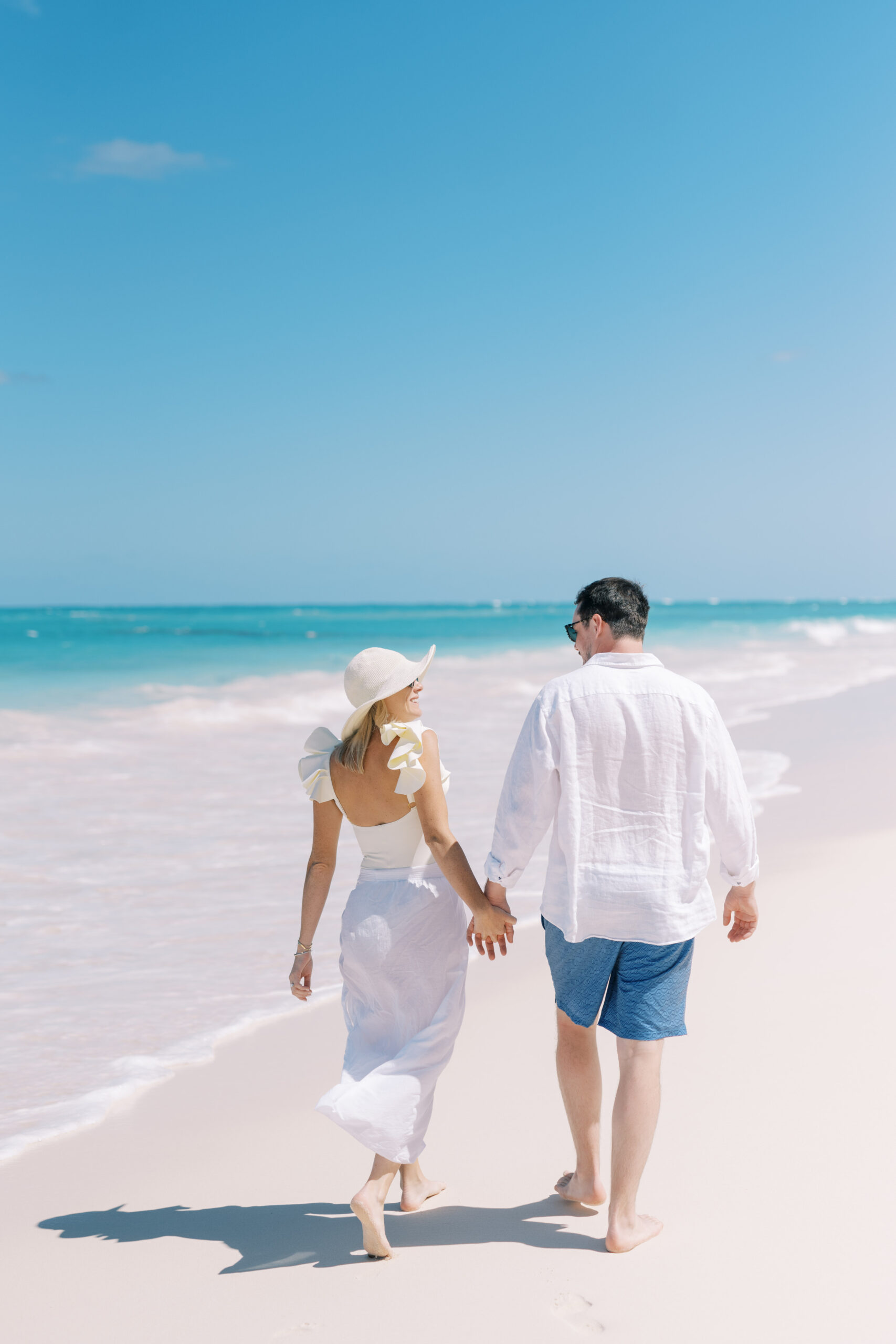 Couple walks on Bahamas Beach during Wedding Weekend Photography by Christine Magee